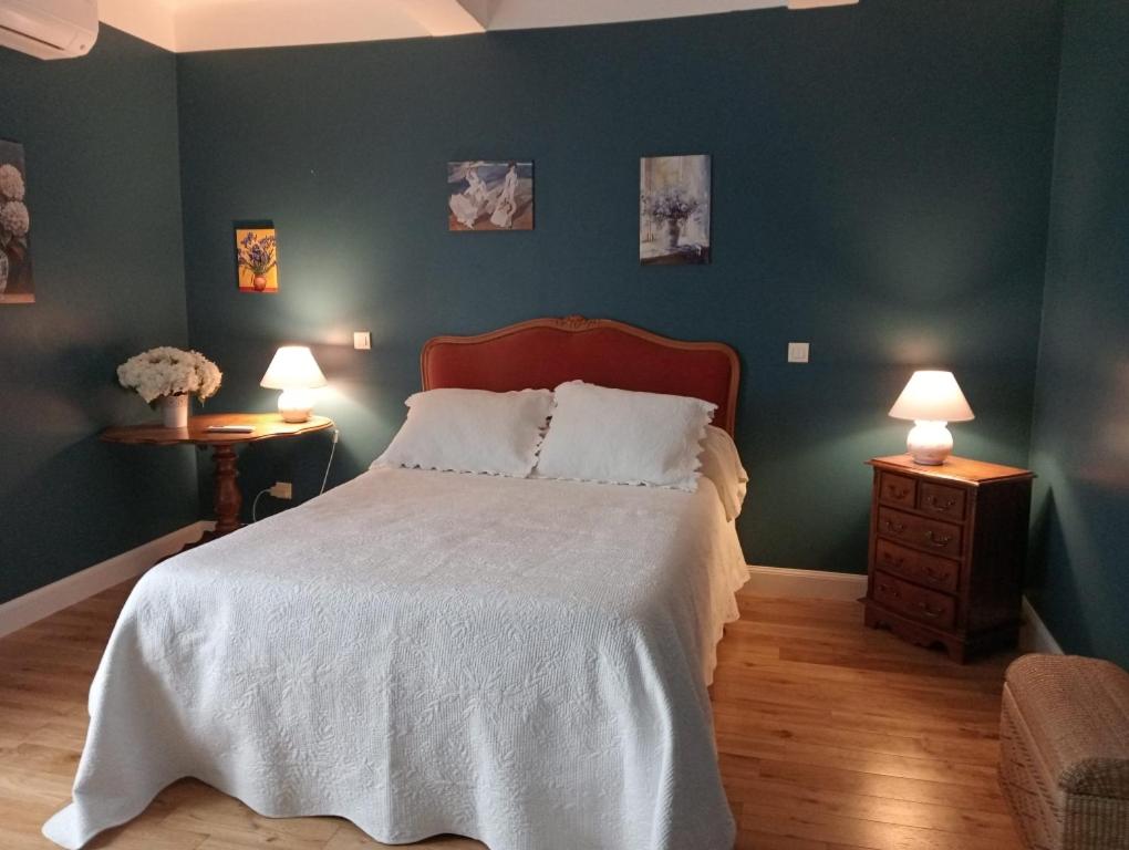 a bedroom with a large bed and two night stands at Chambre d'hôtes in Puimoisson