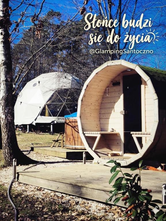 a small building with a round door and a tent at GlampingSantoczno in Santoczno