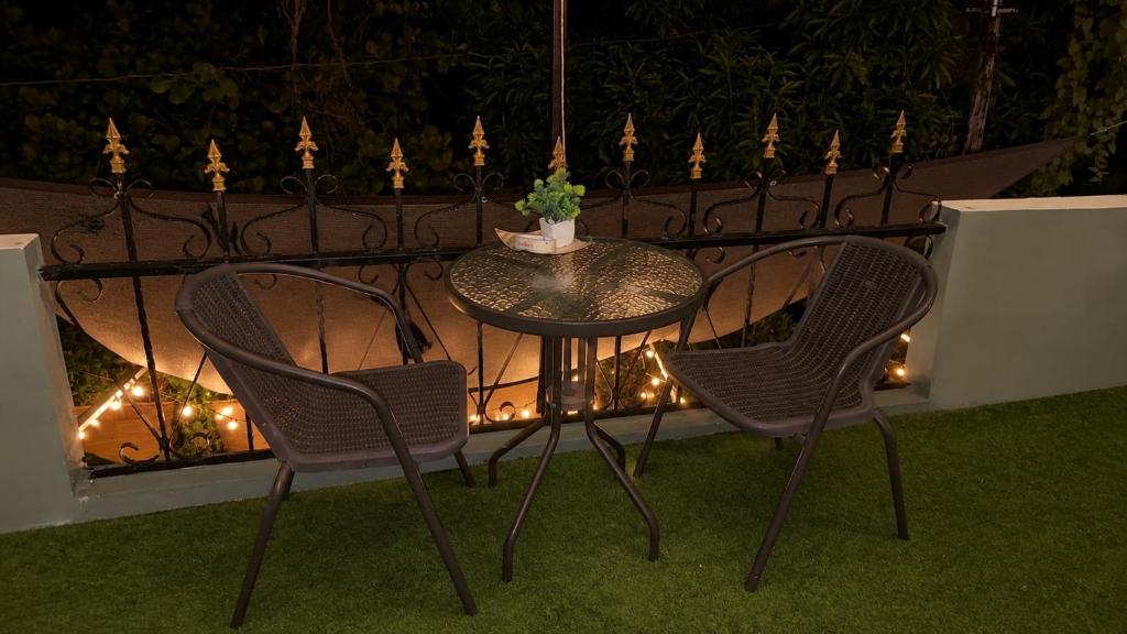 a table and chairs on a balcony with lights at Casa LeValois - Hidden Garden Oasis in Port-Louis in Port Louis