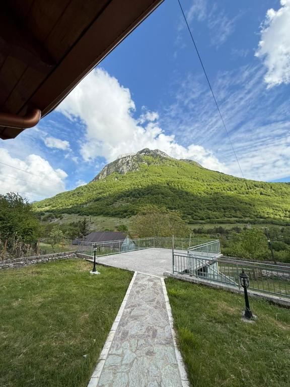 a tennis court with a mountain in the background at Skyline Villa Boge in Bogë