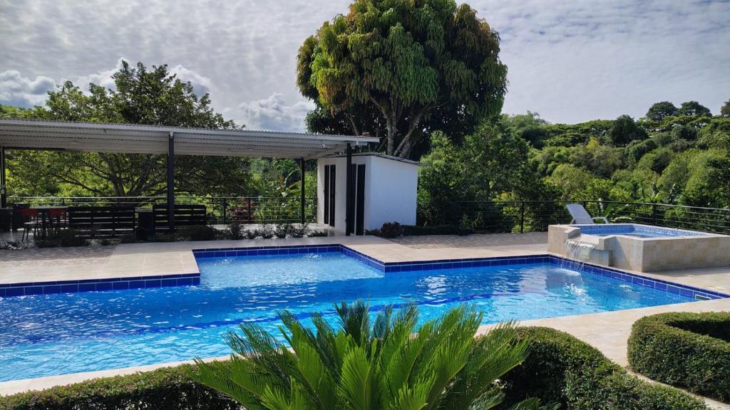 a swimming pool in a yard with a pavilion at Finca Santa Rita in Pereira