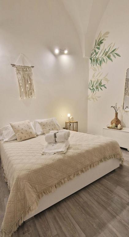 a white bedroom with a large bed with white walls at La Loggia, Historic Center in Grottaglie