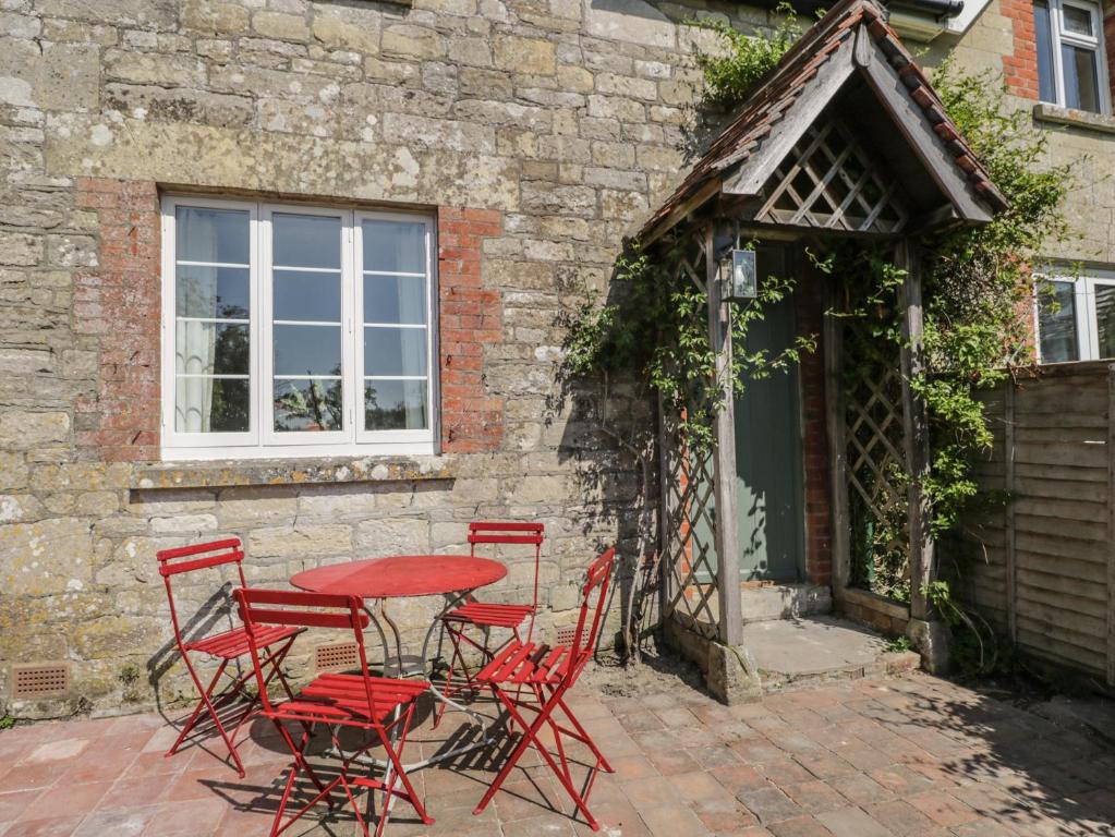 a red table and chairs in front of a building at Middle Cottage in Salisbury