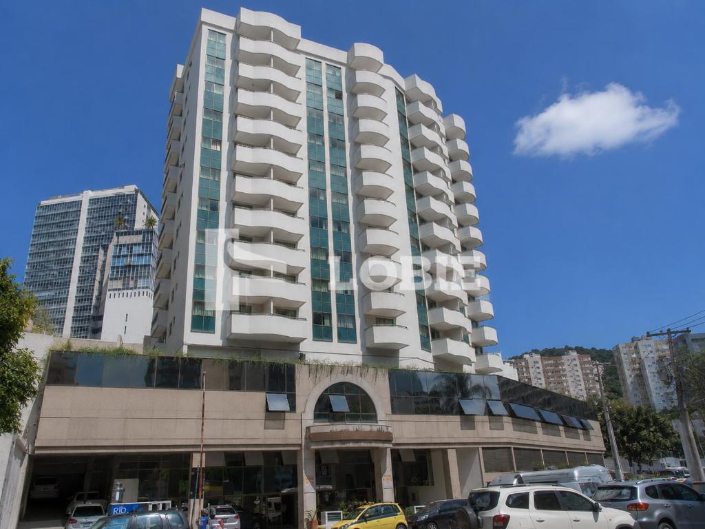 a tall building with cars parked in a parking lot at Lobie Botafogo Privilege in Rio de Janeiro