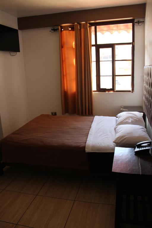 a bedroom with a large bed and a window at hotel turistico in Huaraz