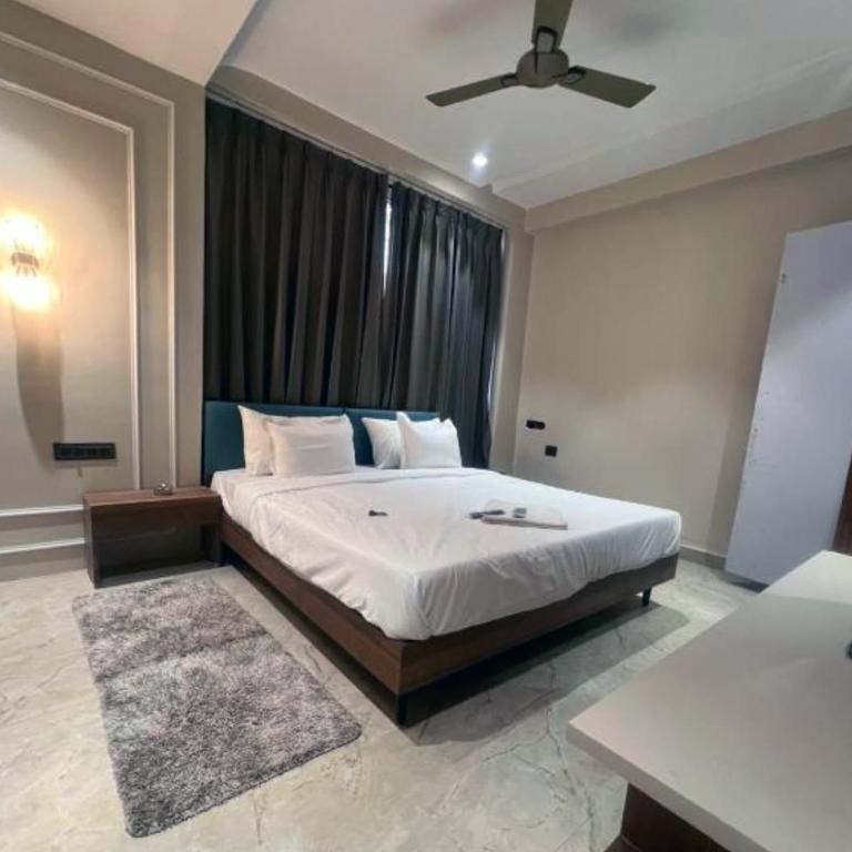 a bedroom with a large bed with a ceiling fan at Hotel Abhilash in Pachmarhī