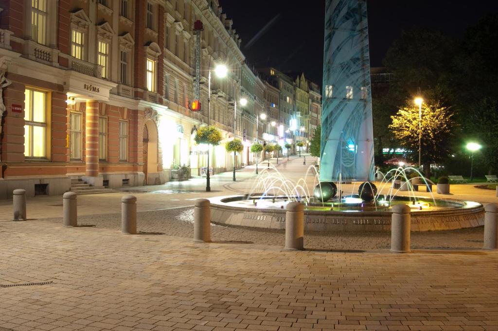 a fountain in the middle of a street at night at KV Apartmány Sokolovská in Karlovy Vary