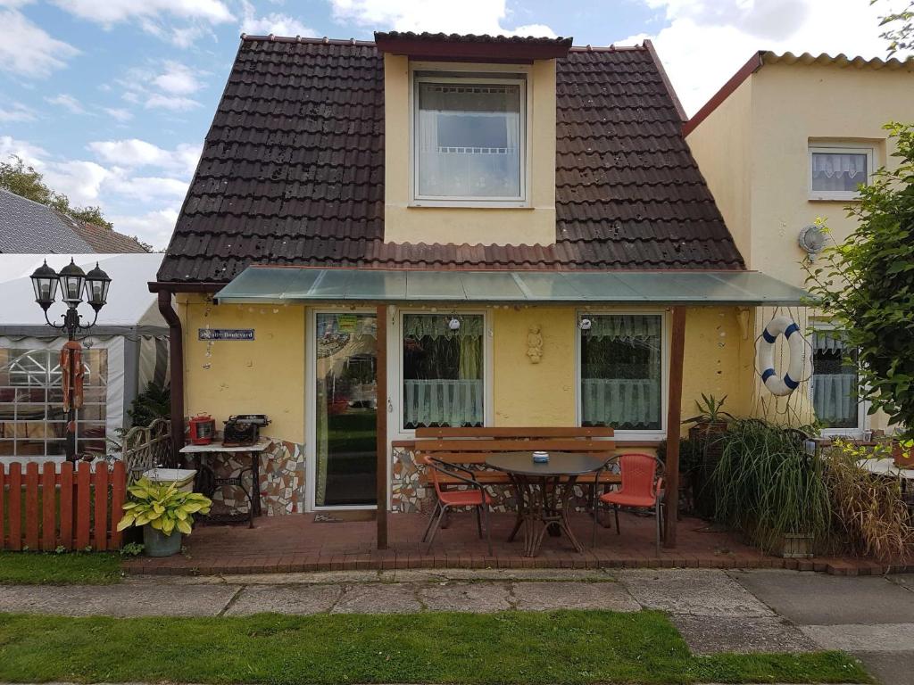 a yellow house with a table and chairs at Ferienwohnungen in Semlow in Semlow