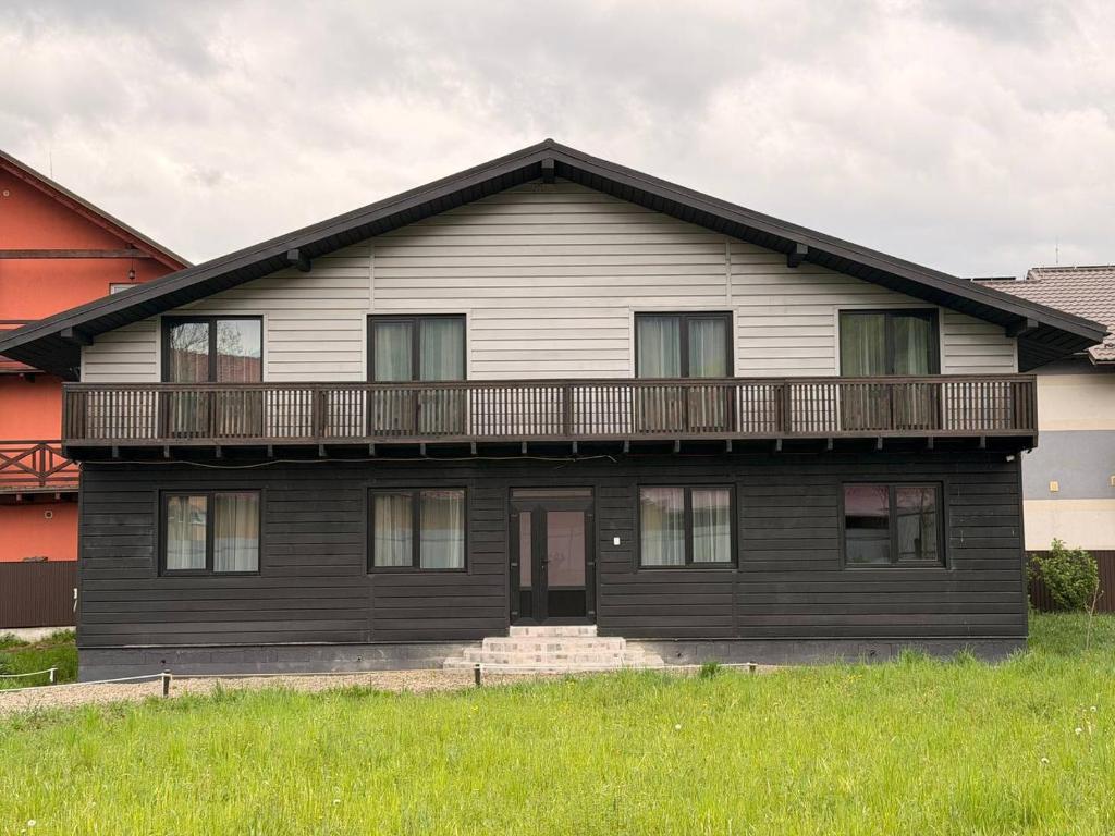 a black house with a balcony on top of it at Садиба ВидНа in Kvasy
