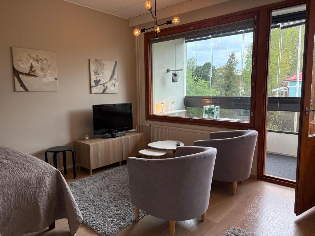 a bedroom with a bed and a tv and a window at Mirella in Tampere
