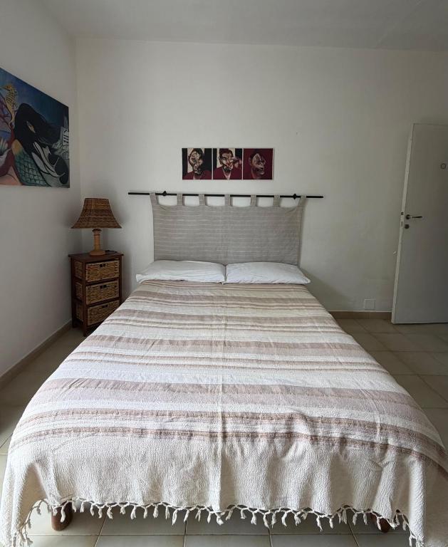 ein Schlafzimmer mit einem großen Bett und einer gestreiften Tagesdecke in der Unterkunft La Stanza in Poggio