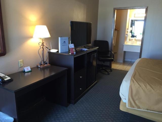 a hotel room with a bedroom with a bed and a desk at Americas Best Value Inn York in York