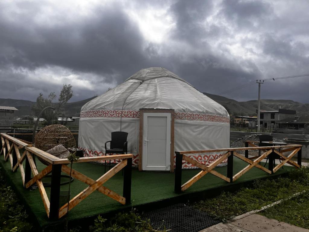 a yurt with a table and a chair in it at Aruna Guesthouse in Saty