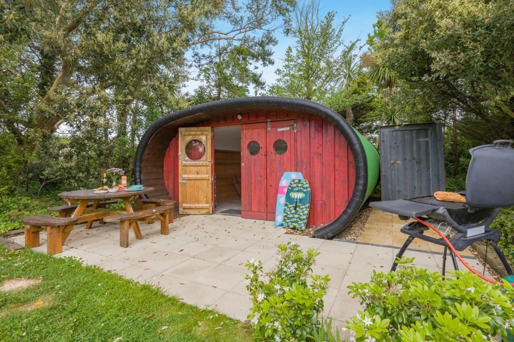 a large red and black play house with a picnic table and a grill at 1 Bed in Bude oc-s34852 in Bude
