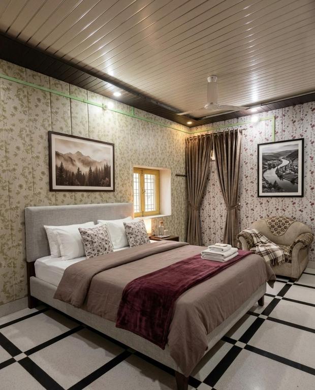 a bedroom with a large bed and a chair at Vaishno Atithi Bhawan in Naimishāranya