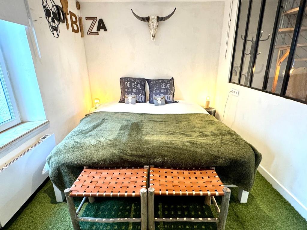 a bedroom with a bed with a cow skull on the wall at La MaisonneTTe d'ElodibiZa ! in Moret-sur-Loing