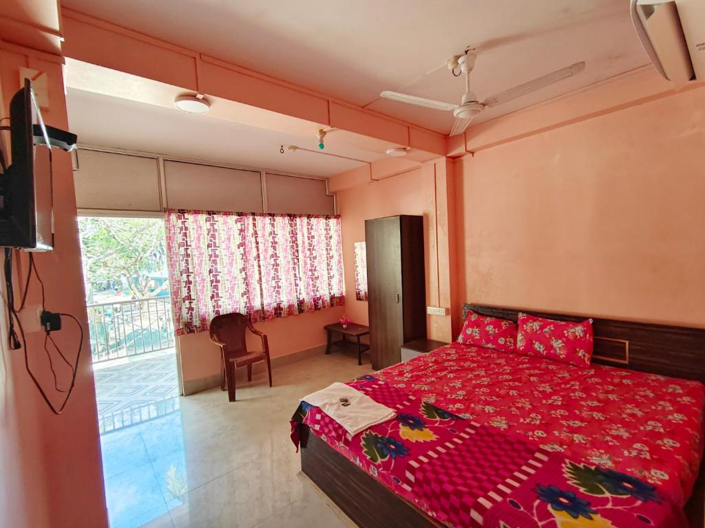 a bedroom with a bed with a red bedspread at Hotel Rajlaxmi in Neil Island