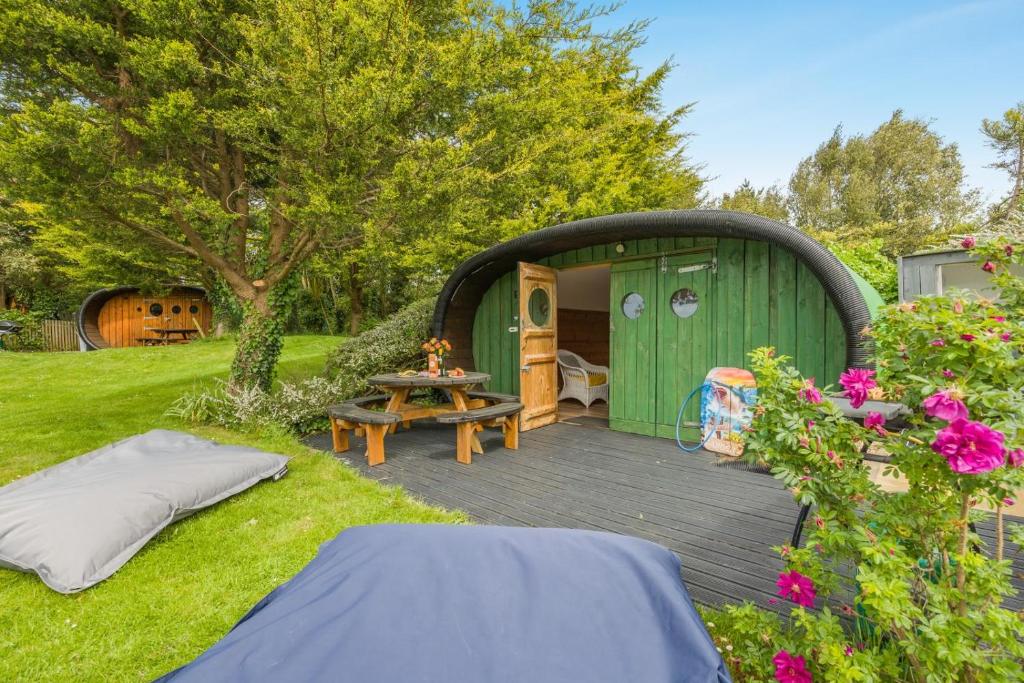 a green gazebo with a picnic table in a yard at 1 Bed in Bude oc-s34850 in Bude