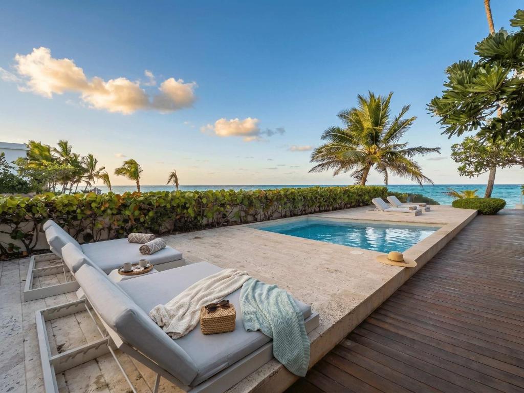 a villa with a swimming pool next to the ocean at 3BR Beachfront Private Pool Ultravioleta Cabarete in Cabarete