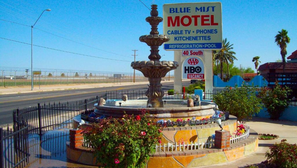 a fountain in front of a motel with a sign at Blue Mist Motel Florence in Florence
