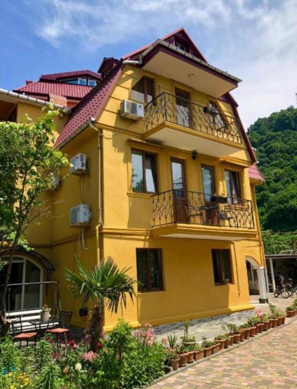a yellow house with a balcony on the side of it at Deluxe Family Stay Near The Beach in Kvariati