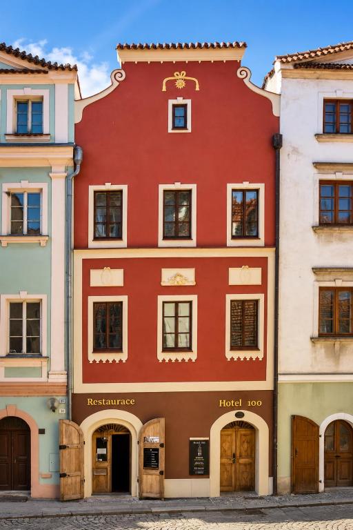 ein rotes Gebäude inmitten zweier Gebäude in der Unterkunft Hotel 100 in Pardubice