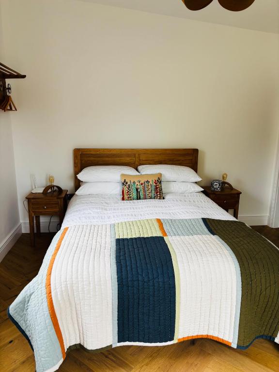 a bedroom with a bed with a colorful blanket on it at Barnfield house in Upham