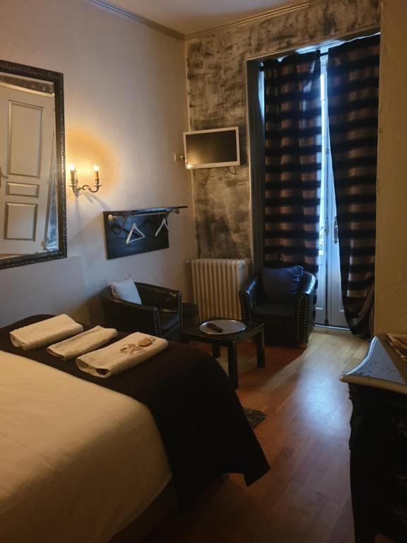 a hotel room with a bed and a chair at l'authentique in Saint-Amand-Montrond