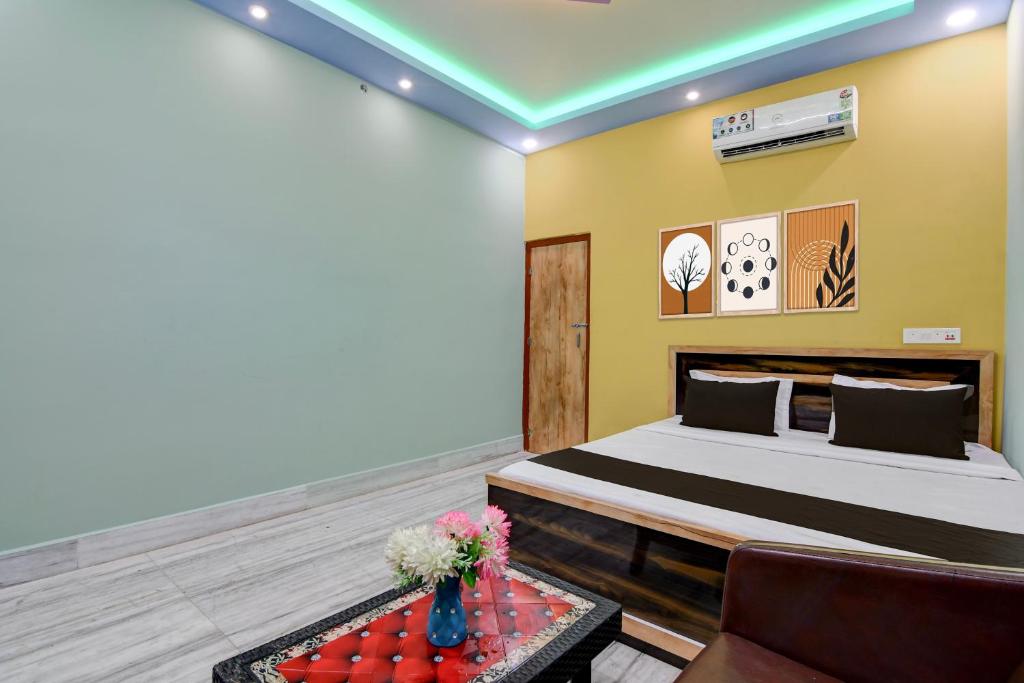a bedroom with a bed and a couch and a table at Hotel O by OYO AM2PM Restaurant Cum Bar in Jangipur