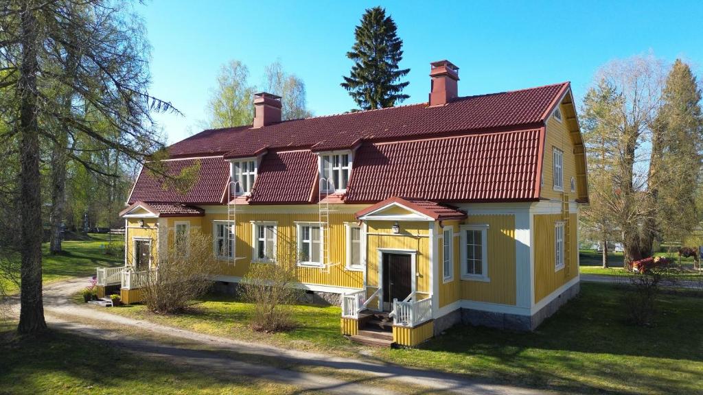 a yellow house with a red roof at Majatalo Mäntän Kuusela in Mänttä