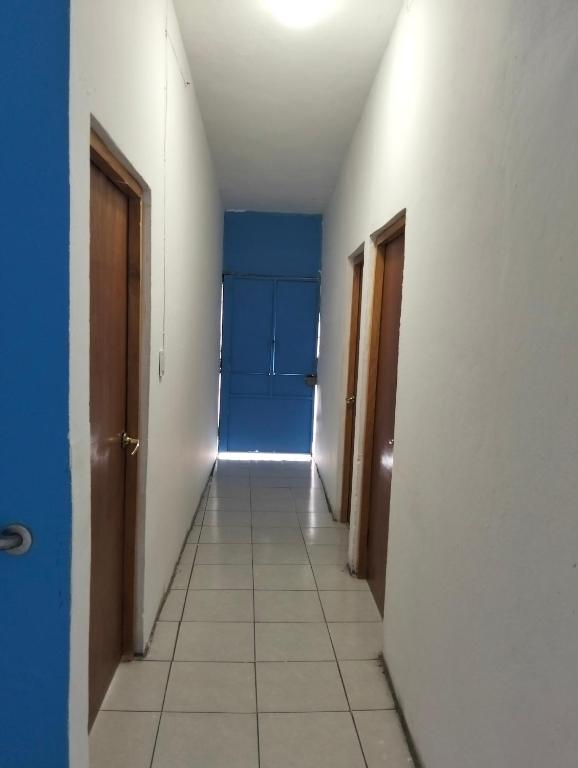 an empty hallway with a room with blue walls and white floors at Tu hogar en tapachula in La Concepción