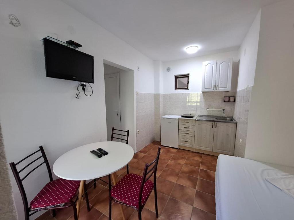 a room with a table and chairs and a kitchen at Canj Cozy apartment - Studio in Čanj