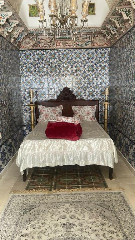 a bedroom with a bed in a room with wallpaper at Beit Khalifa in Kairouan