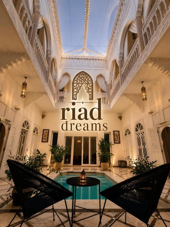 a hotel lobby with a pool and a sign that reads had dreams at RIAD DREAMS in Marrakesh