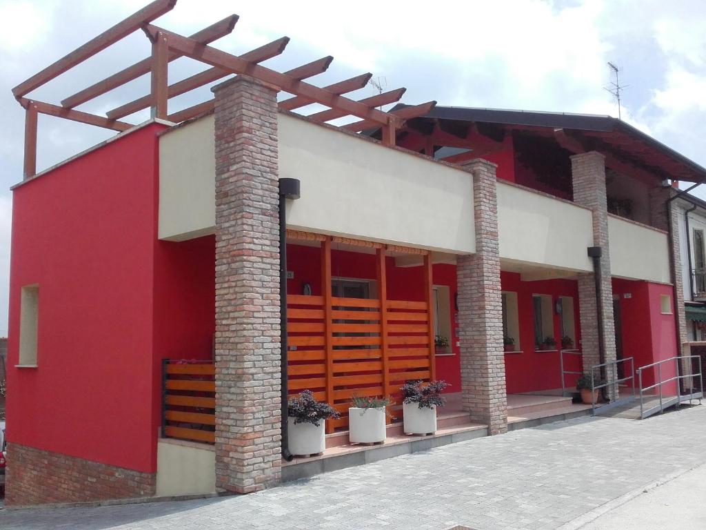 un edificio rojo y blanco con dos columnas de ladrillo en La Via Del Volano, en Codigoro