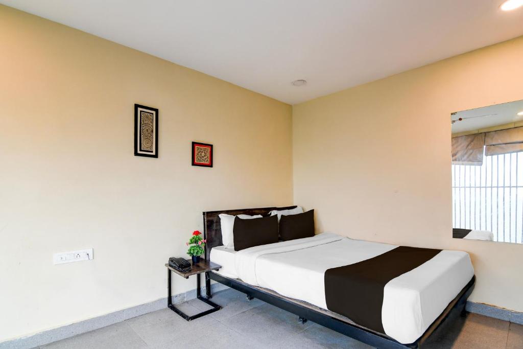 a bedroom with a bed and a window at Hotel O Premium 12th Night in kolkata