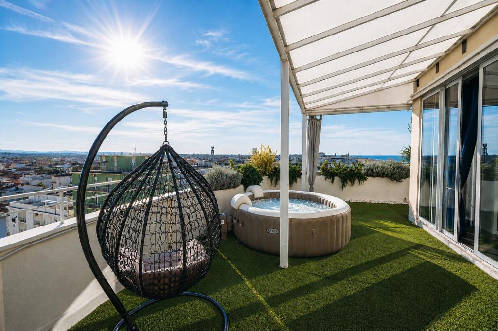 a balcony with a hammock and a hot tub at Suite Apartments Rimini - Seafront in Rimini