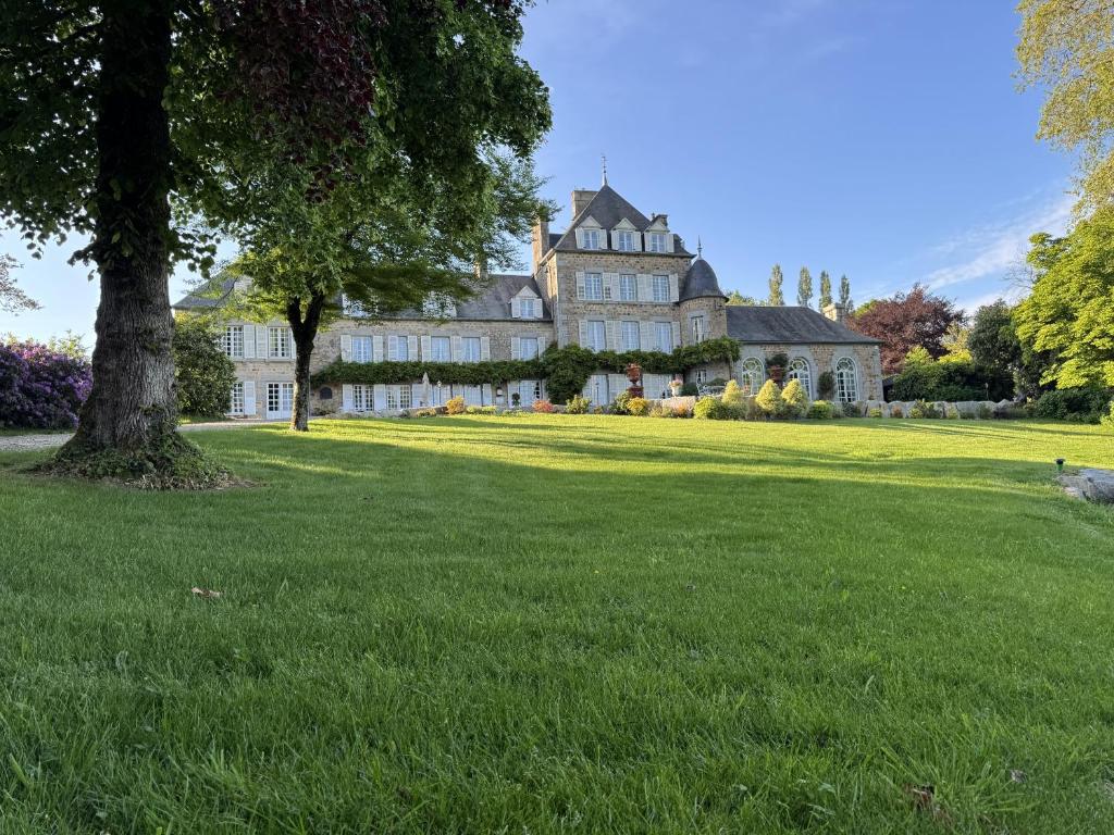 a large house on a green lawn with a tree at Château La Rametière in Le PARC