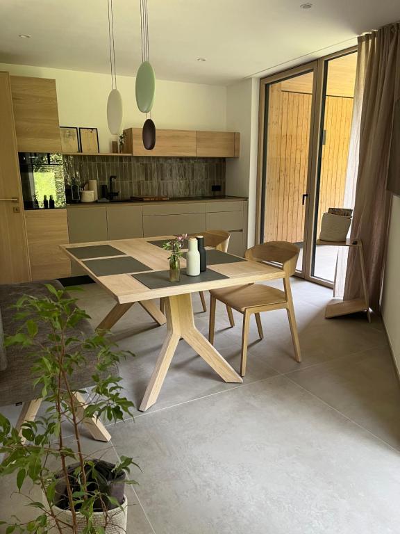 a kitchen with a wooden table and chairs in a room at The Mountain Nest in Russbach am Pass Gschütt