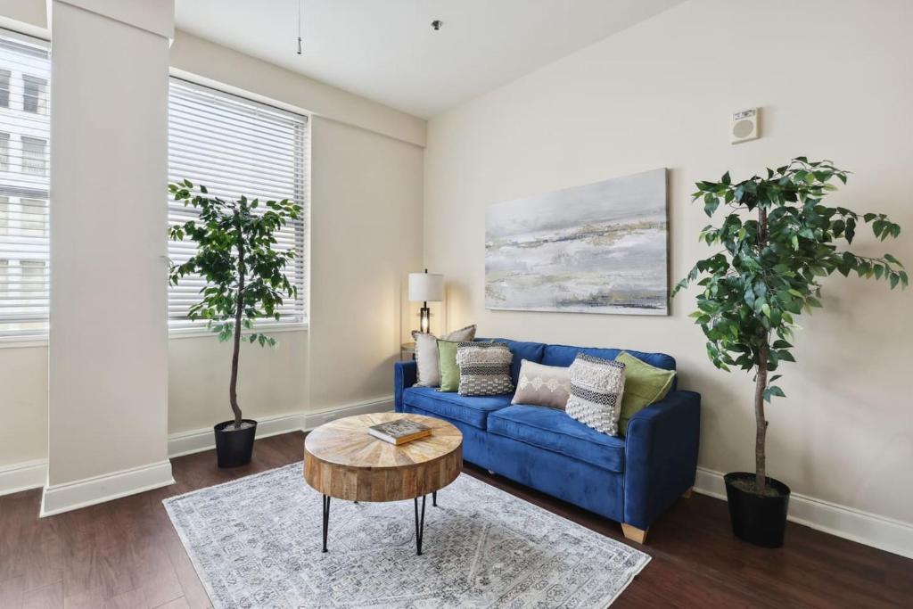a living room with a blue couch and a table at Suite Bleu 5 Min walk to Bourbon st Rooftop Pool in New Orleans