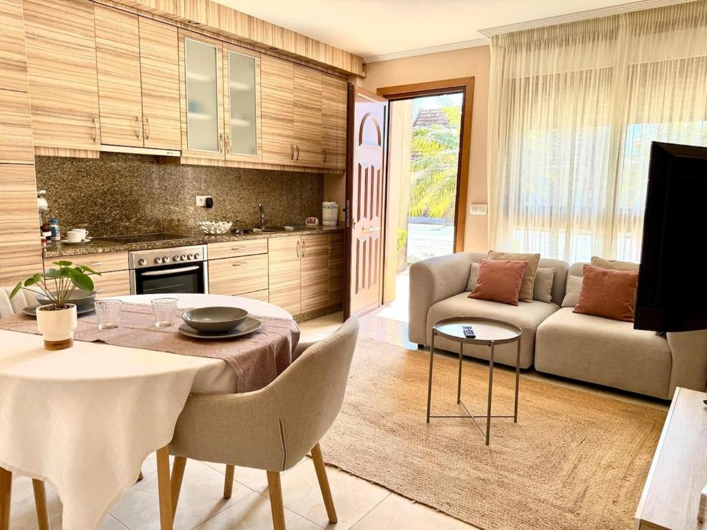 a kitchen and living room with a table and a couch at Apartmento Las Palmeras in Noalla