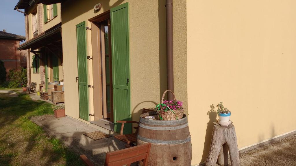 a building with a green door and a barrel at B&B Il Nocciolino in La Fabbrica