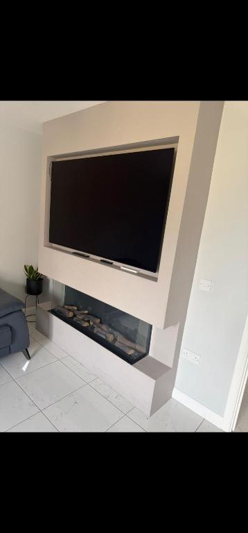 a large flat screen tv sitting on top of a fireplace at edinburgh holiday home in Roslin