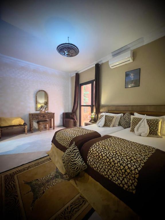 a bedroom with two beds in a room at Hotel tafoukt in Marrakesh