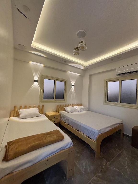 two beds in a room with windows at Villa Solla Dahab in Dahab