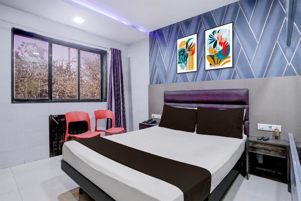 a bedroom with a bed and two red chairs at Hotel O Jayesh Inn in Kolshet