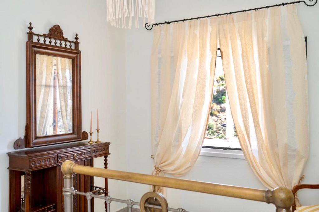 a bedroom with a window and a bed and a mirror at Demetra Waterfront House-Authentic Syros, by Elefthia Syros in Megas Gialos - Nites