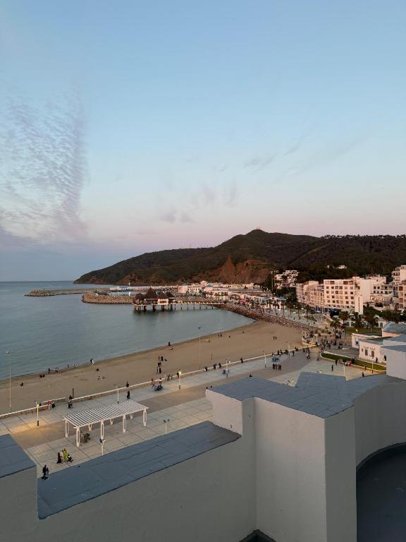 a view of a beach with a pier and buildings at Étoile in M'diq