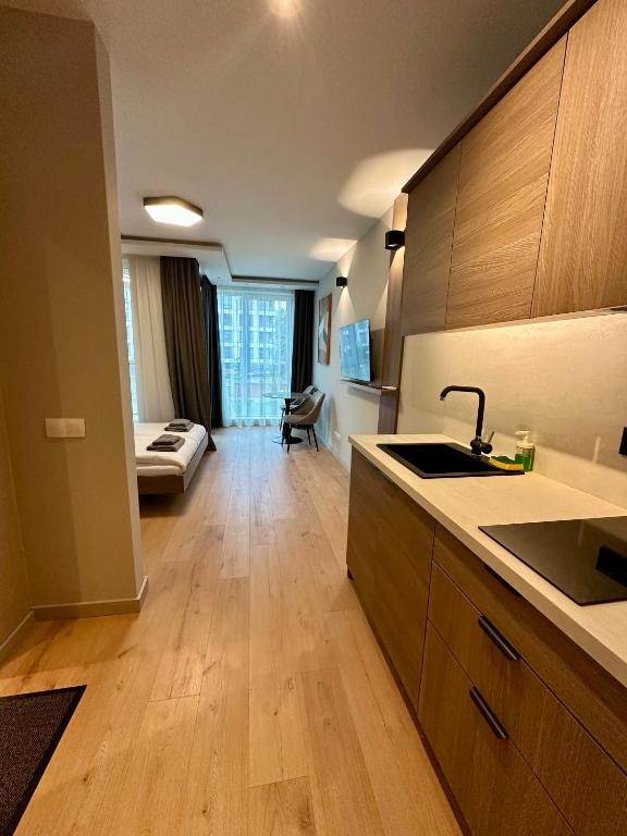 a kitchen with a sink and a living room at Eleve Residences - Sand Studio in Sofia