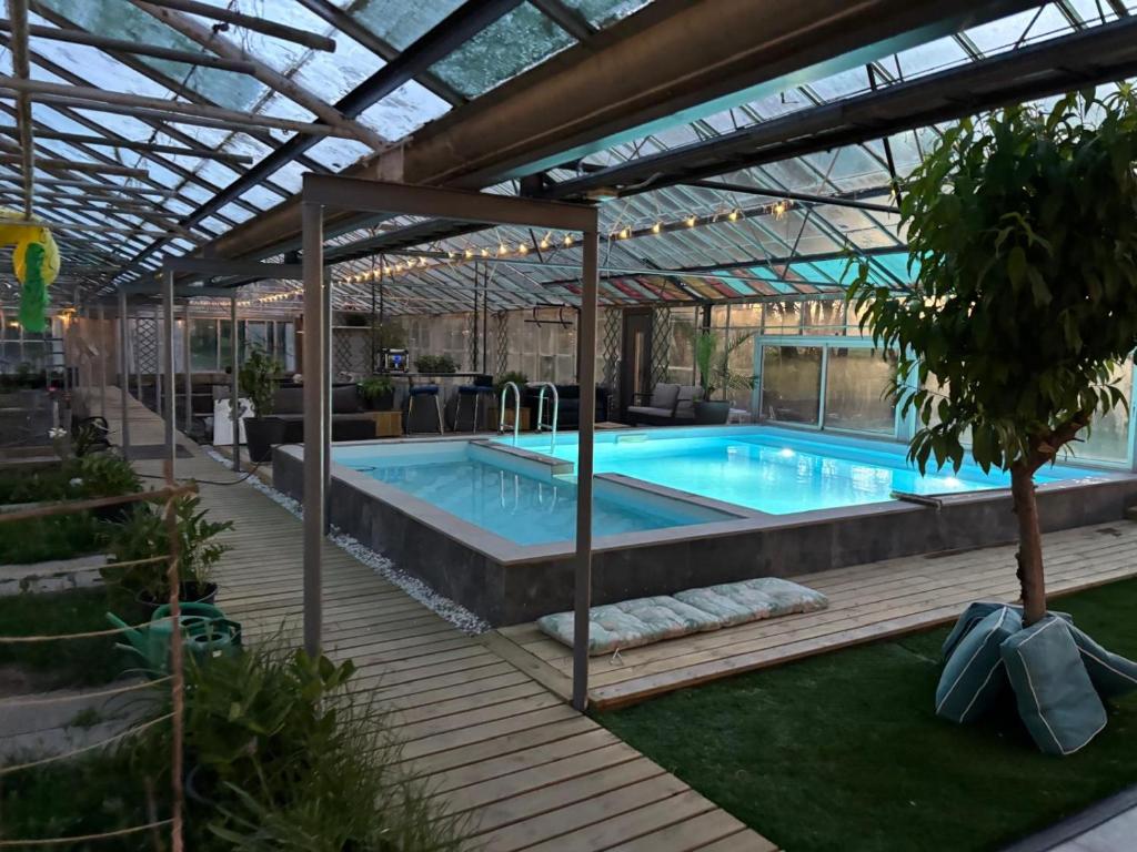 a swimming pool with a pergola and a swimming pool at Köpingebro in Köpingebro